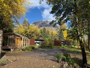 a house in the woods with a mountain in the background at Hotel Patagonia House in Coihaique