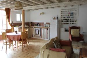a living room with a table and a kitchen at La maison bleue des Pyrénées in Argut-Dessous