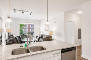 a kitchen with a sink and a living room at Modern Apt Downtown with Pool in Stamford