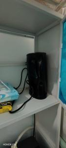 a black vase sitting on a shelf in a closet at ZIRA STAY PENARIK - Ziyad Room in Kampong Ru Sepuloh