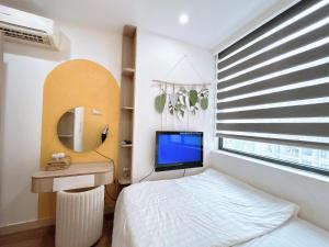 a bedroom with a bed and a mirror and a television at Minh Anh Apartment 5 in Thôn Văn Dương