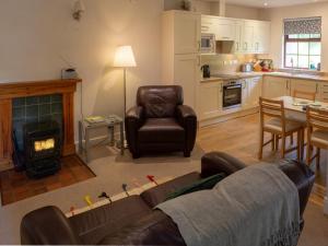 a living room with a couch and a chair and a fireplace at 1 Bed in Applecross oc-ca186 in Applecross