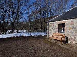 a wooden bench sitting outside of a stone building at 1 Bed in Applecross oc-ca186 in Applecross +16 photos
