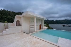 a villa with a swimming pool and a house at Holista Bali in Kubupenlokan