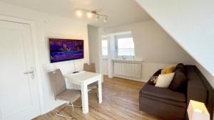 a living room with a couch and a table at Westerheide 51, App 1 in Wenningstedt