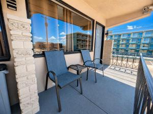 two chairs on a balcony with a view of a city at Paradise Inn in Wildwood