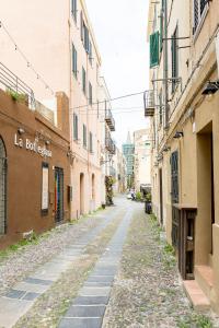 an empty street in an alley between buildings at Casa Rica in Alghero