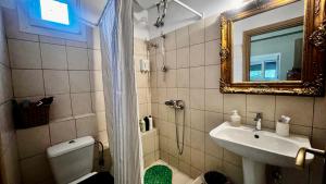 a bathroom with a sink and a toilet and a mirror at Studio close to Train Station in Larisa +13 photos