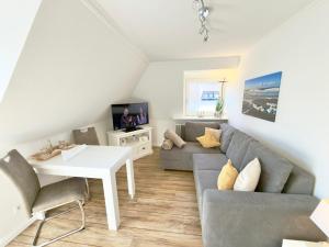 a living room with a couch and a table at Westerheide 51, App 2 in Wenningstedt