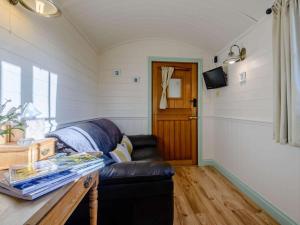 a living room with a leather couch and a table at 1 Bed in Conwy oc-79464 in Conwy