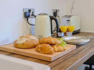 a cutting board with bread and croissants on a counter at 1 Bed in Conwy oc-79464 in Conwy +8 photos