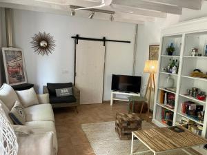 a living room with a couch and a tv at Es Campet, charmante finca, Soller, Vue splendide, piscine, calme in Sóller