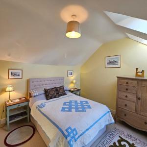 a bedroom with a large bed and a dresser at Talbot Lodge BnB - Two ensuite bedrooms, near Bicester in Middleton Stoney