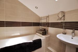 a bathroom with a bath tub and a sink at Talbot Lodge BnB - Two ensuite bedrooms, near Bicester in Middleton Stoney