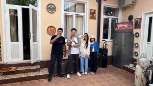 a group of people standing outside of a house at Sole Family Guesthouse in Samarkand
