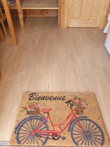 a rug with a red bike on it on a wooden floor at Roulotte bohème in Chazelles