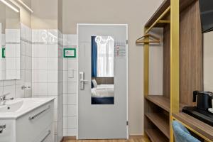 a white bathroom with a sink and a mirror at Odeon near Nestroyplatz with Self Check-in & Private External Bathroom in Vienna