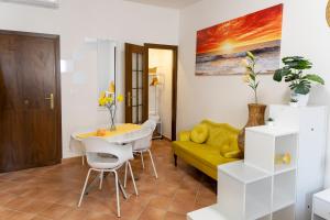 a living room with a yellow couch and a table at Casa Rica in Alghero