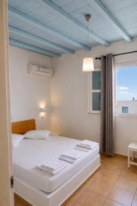 a bedroom with a white bed with a blue ceiling at Filoxenia Apartments in Adamantas