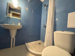 a blue tiled bathroom with a toilet and a sink at Krasi Apartments in Perla Complex in Pomorie +45 photos