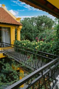 a balcony of a yellow house with flowers at Tam Coc Mango Homestay - Free Swimming Pool in Ninh Binh +88 photos