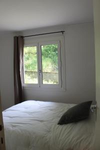 a bedroom with a bed and a window at La maison bleue des Pyrénées in Argut-Dessous