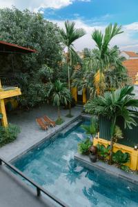 a swimming pool in a resort with palm trees at Tam Coc Mango Homestay - Free Swimming Pool in Ninh Binh