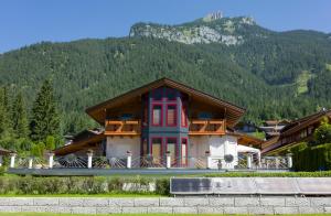 a building with red and blue doors and a mountain at Ferienwohnung Biechl in Maurach