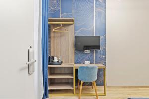 a desk with a tv and a chair in a room at Odeon near Nestroyplatz with Self Check-in & Private External Bathroom in Vienna
