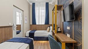 a hotel room with two beds and a tv at Odeon near Nestroyplatz with Self Check-in & Private External Bathroom in Vienna