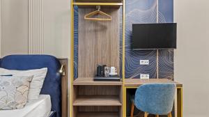 a room with a bed and a desk with a tv at Odeon near Nestroyplatz with Self Check-in & Private External Bathroom in Vienna