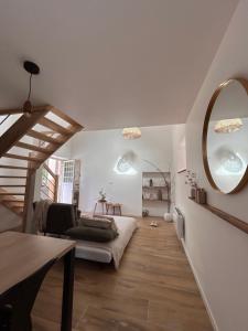 a living room with a couch and a mirror at Ker Rev Home Gîte indépendant de charme en longère bretonne in Quimper +27 photos
