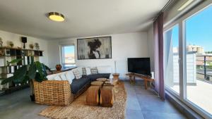 a living room with a couch and a tv at A l'aube de Bali in Amnéville