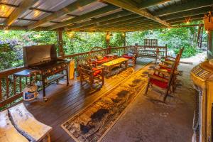 a porch with chairs and a piano on a deck at The Lodge in Helen