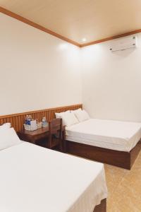 a room with two beds and a table at Tam Coc Mango Homestay - Free Swimming Pool in Ninh Binh