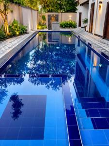 a swimming pool with blue tiles in a house at Araliya Villa in Tangalle
