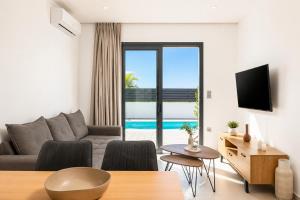 a living room with a couch and a tv and a table at Villa Salty Sun 6 in Kremasti