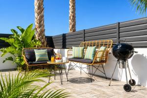 a patio with two chairs and a table and a grill at Villa Salty Sun 6 in Kremasti