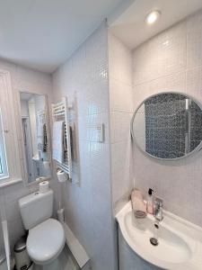 a white bathroom with a toilet and a sink at Large 3 bed 2 bath modern apartment in Finchley