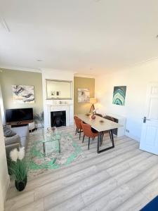 a living room with a table and a fireplace at Large 3 bed 2 bath modern apartment in Finchley