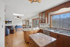 a kitchen with wooden cabinets and a large window at Vista Ridge at Alpine 4BDR in Jasper