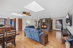a living room with a blue couch and a fireplace at Vista Ridge at Alpine 4BDR in Jasper