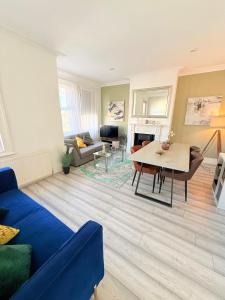 a living room with a blue couch and a table at Large 3 bed 2 bath modern apartment in Finchley +8 photos