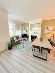 a living room with a table and a couch at Large 3 bed 2 bath modern apartment in Finchley