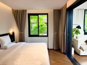 a bedroom with a large white bed and two windows at 璞宿清居民宿 in Xi'an