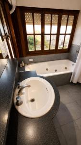 a bathroom with a sink and a bath tub at Mojomar Pinamar Hotel in Pinamar +23 photos