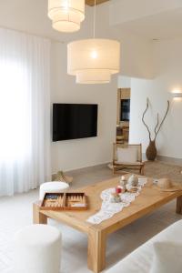 a living room with a coffee table and a tv at Eos Milos House in Pollonia