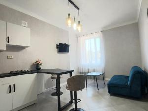 a small kitchen with a table and a blue chair at Центр,дитяче містечко Казка in Mykolaiv +4 photos