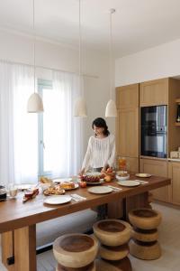 a woman standing at a table in a kitchen at Eos Milos House in Pollonia
