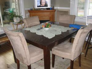 a dining room table with chairs and a table with a bowl of flowers at B&B Le Transit in Quebec City